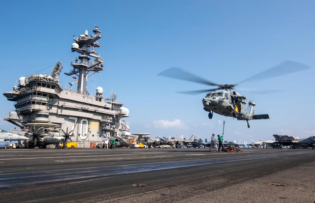 This photograph released by the US Navy shows a MH-60S Sea Hawk helicopter hovering over the USS Carl Vinson aircraft carrier while operating in the Middle East on April 12.