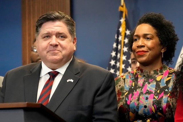Illinois Gov. J.B. Pritzker stands with Lt. Gov. Juliana Stratton during the Illinois Paid Leave bill signing ceremony, in Chicago, on March 13, 2023.
