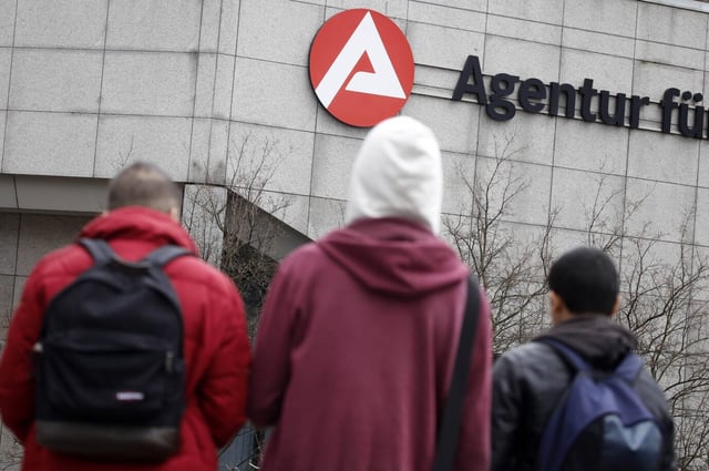 Drei junge Männer in Kapuzen stehen vor dem Arbeitsamt – die Staatsausgaben und die Staatsquote sind in Deutschland in die Höhe geschnellt – auch wegen der vielen migrantischen Bürgergeldempfänger