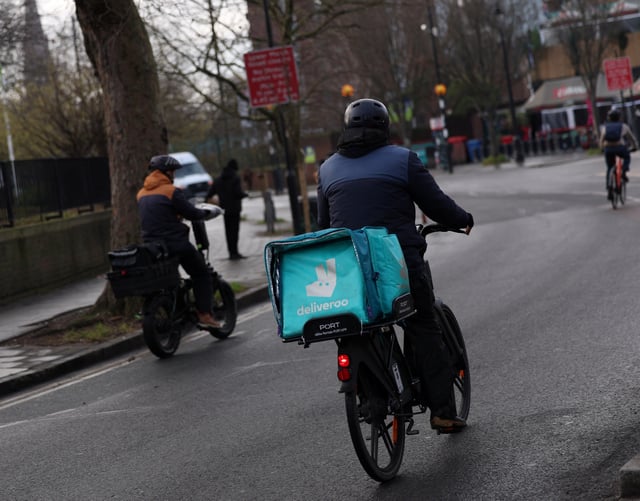 A delivery worker with a backpack of Deliveroo rides a bike in London, Britain, January 16, 2025. REUTERS/Isabel Infantes/File Photo