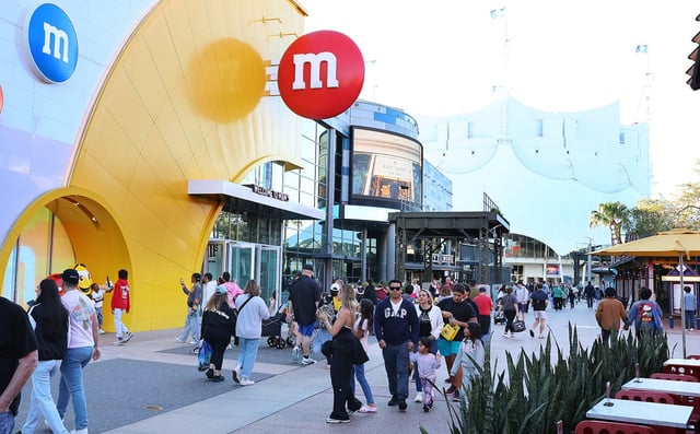 Visitors walk among storefronts at Disney Springs on Tuesday, Feb. 25, 2025. (Stephen M. Dowell/Orlando Sentinel)