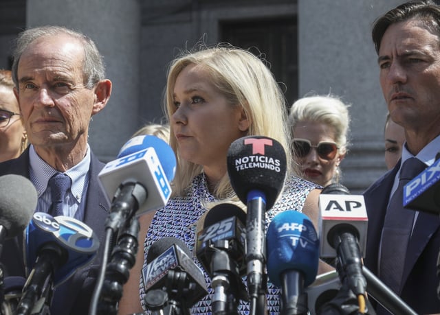 FILE - Virginia Giuffre, center, holds a news conference outside a Manhattan court in New York, Aug. 27, 2019. (AP Photo/Bebeto Matthews, File)