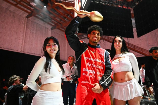 Tristan Mykel of USC holds a golden sperm trophy after winning the Sperm Racing competition