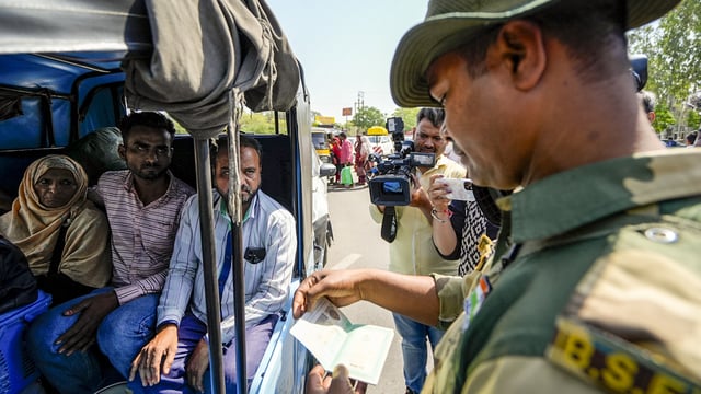 A BSF jawan checks documents of Pakistani nationals as they arrive at the Integrated Check Post at the Attari-Wagah border.
