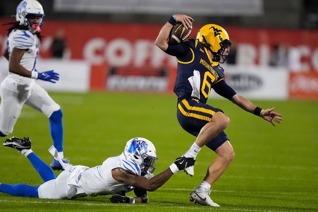 Memphis defensive back Kobee Minor trips West Virginia quarterback Garrett Greene in the Frisco Bowl on Dec. 17, 2024.