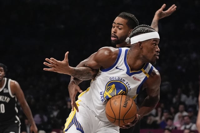Golden State Warriors’ Jimmy Butler III, right, spins away from Brooklyn Nets’ D’Angelo Russell during the second half of an NBA basketball game Thursday, March 6, 2025, in New York. (AP Photo/Frank Franklin II)