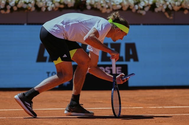 Alexander Zverev macht mit seinem Handy ein Foto vom Ballabdruck.