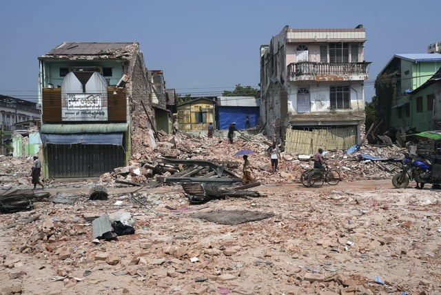 Volunteers help to clear a collapsed building after one month of the strong earthquake, in Naypyitaw, Myanmar, Monday, April 28, 2025. (AP Photo/Aung Shine Oo)
