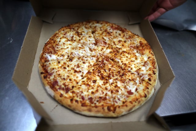 A pizza comes out of the oven at Domino's Pizza restaurant in Los Angeles, California, U.S. July 18, 2018. REUTERS/Lucy Nicholson/File Photo