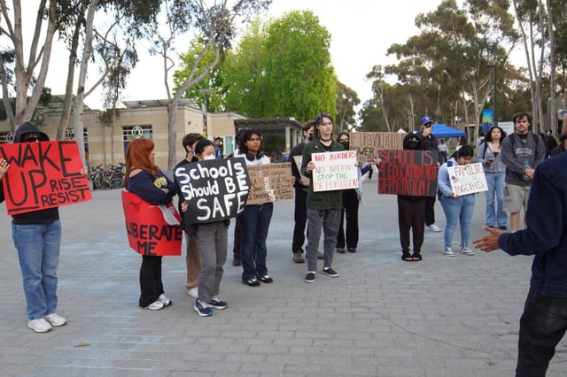 People hold placards during a student demonstration. Since Donald Trump’s presidency, thousands of international students have had their visas revoked by the U.S. government. At the University of California, at least 36 students have had their visas revoked or were refused entry into the United States. On April 23, approximately 20 people protested on campus in response to the visa terminations. (Photo by Michael Ho Wai Lee / SOPA Images/Sipa USA)(Sipa via AP Images)