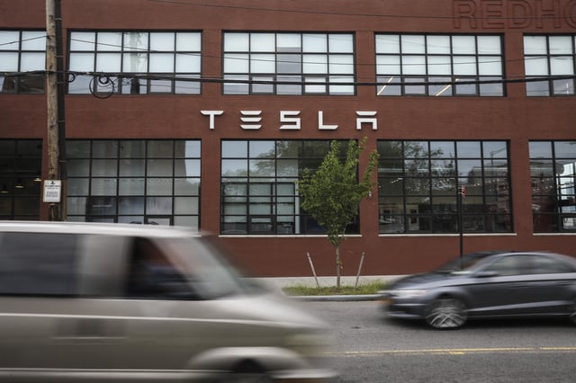 Cars drive by a Tesla dealership in New York City&#39;s Red Hook neighborhood on August 7, 2018.