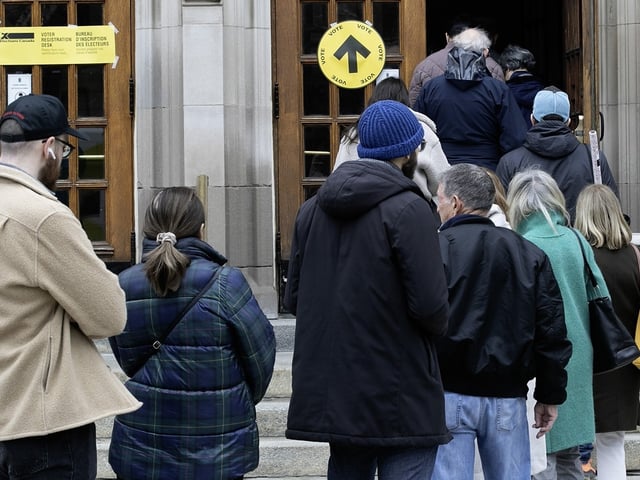 Voters wait in line as they arrive to vote in the advance poll at Victoria Hall in Westmount, on Friday April 18, 2025.