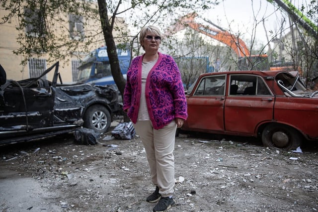 Olena Khirkovska stands in front of her destroyed car and wrecked apartment building after a large-scale Russian air attack in Kyiv, Ukraine, April 24, 2025. 