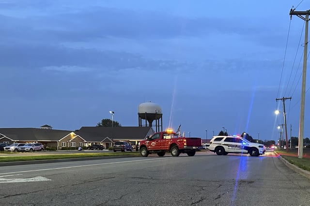 Emergency vehicles block a road leading to a building where a car smashed through during an after-school program, killing several people and injuring others, Monday, April 28, 2025, in Chatham, Ill. (AP Photo/John O'Connor)