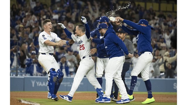 The Dodgers’ Tommy Edman (25) celebrates with catcher Will Smith, left, among others after Edman’s two-run walk-off single in the 10th inning gave them a 7-6 victory over the Miami Marlins on Monday night at Dodger Stadium. (AP Photo/Kyusung Gong)