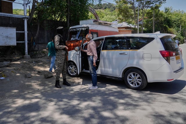 An Indian paramilitary soldier talks with tourists outside a garden in Srinagar after it was closed by authorities as a precautionary safety measure following last week's deadly attack on tourists near the resort town of Pahalgam, Indian controlled Kashmir, Tuesday, April 29, 2025. (AP Photo/Mukhtar Khan)