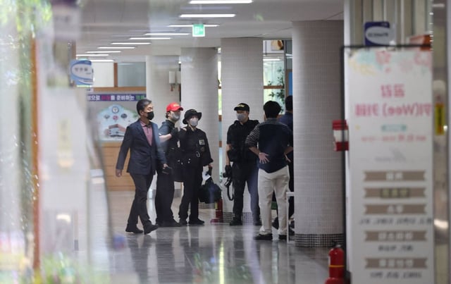 Members of a South Korean Police Crime Scene Investigation team probe a high school in Cheongju on April 28 after a knife attack by a student left seven injured. Photo: AFP