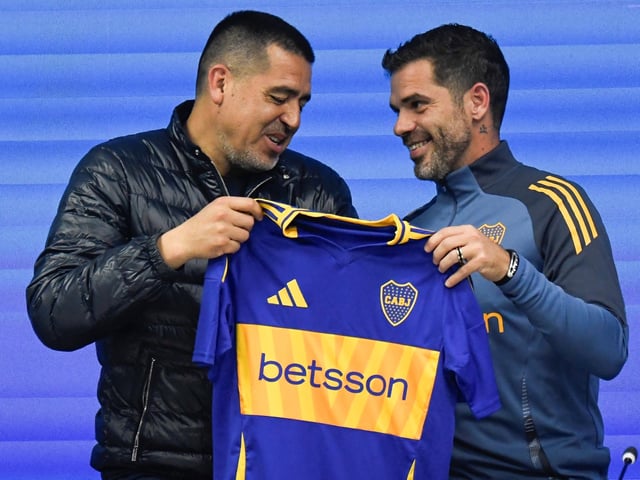 Fernando Gago, right, poses for photos with a Boca Juniors jersey during his media presentation as the soccer team's coach, alongside club President Juan Roman Riquelme, in Buenos Aires, Argentina, Monday, Oct. 14, 2024. (AP Photo/Gustavo Garello)