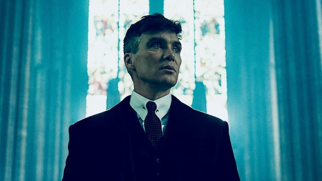 Cillian Murphy in front of a stained-glass window in Peaky Blinders.