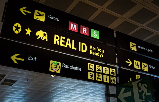 Stock image/file photo: Illuminated airport signage notifying travelers of REAL ID requirements.