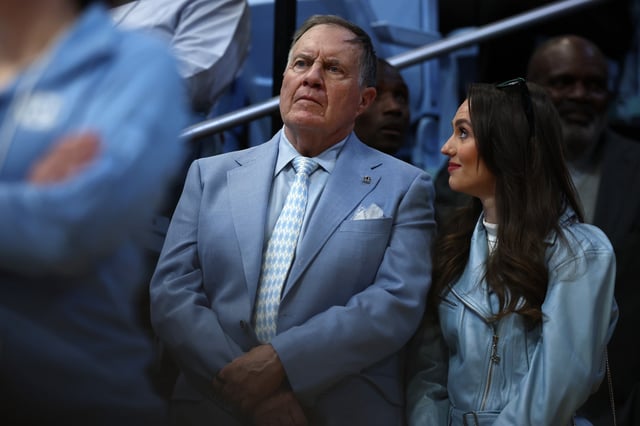 North Carolina Tar Heels football head coach Bill Belichick and his girlfriend Jordon Hudson look on during the first half of the game between the North Carolina Tar Heels and the Duke Blue Devils.