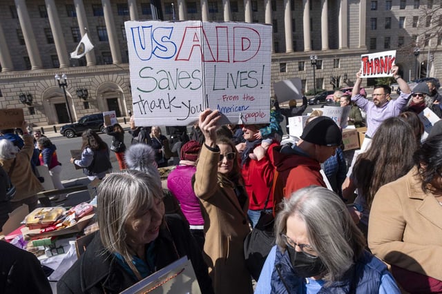 Demonstrators protest mass firings at USAID on Feb. 28, 2025, in Washington D. C. San Francisco and Santa Clara filed suit against the Trump administration Monday, arguing sweepings firings surpass the president&#39;s authority.