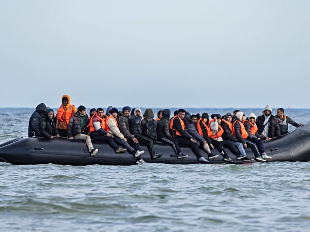 Migrants board a smuggler's boat in an attempt to cross the English Channel, off the beach of Gravelines, north of France, on March 26, 2025. (Photo by Sameer Al-DOUMY / AFP)
