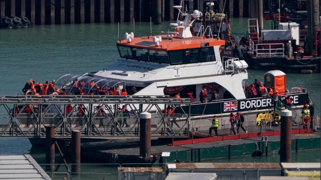 Migrants arrive at Dover with Border Force agents on Tuesday