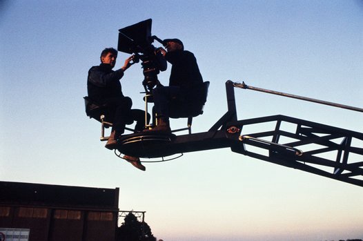 TWO MEN WITH MOVIE CAMERA, IN ELEVATED POSITION