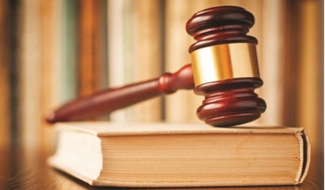 A judge&#39;s gavel rests on a book of law.
