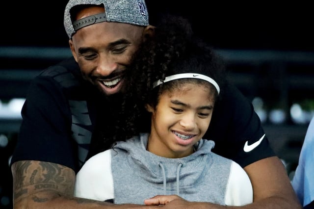 Former Los Angeles Laker Kobe Bryant and his daughter Gianna watch during the U.S. national championships swimming meet in Irvine, Calif., on July 26, 2018.