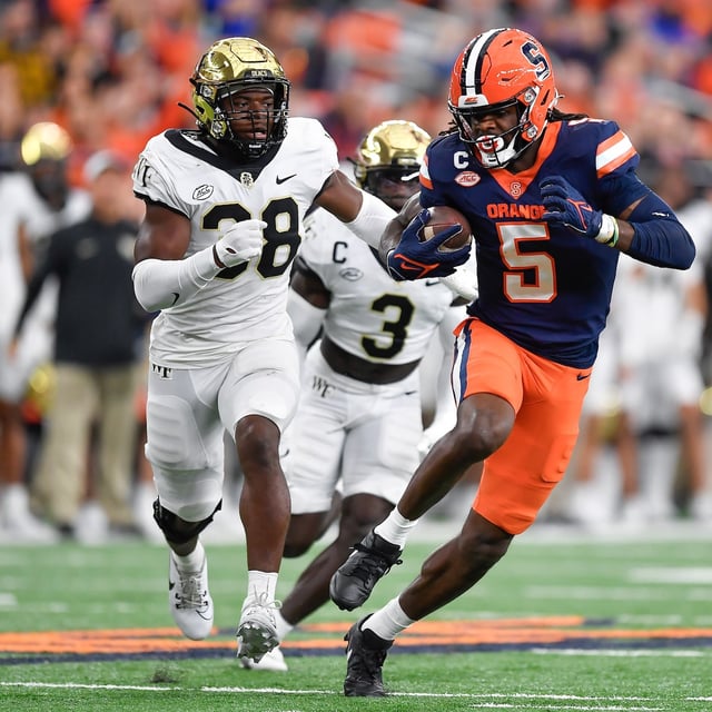 Syracuse wide receiver Damien Alford, right, outruns Wake Forest defensive back Davaughn Patterson for a score during the first half of an NCAA college football game in Syracuse, N.Y., Saturday, Nov. 25, 2023. (AP Photo/Adrian Kraus)