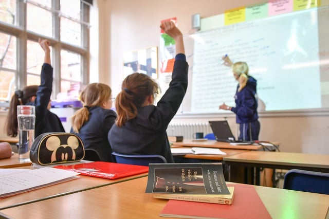 A teacher and students in a classroom. Stock photo: PA Images / Alamy