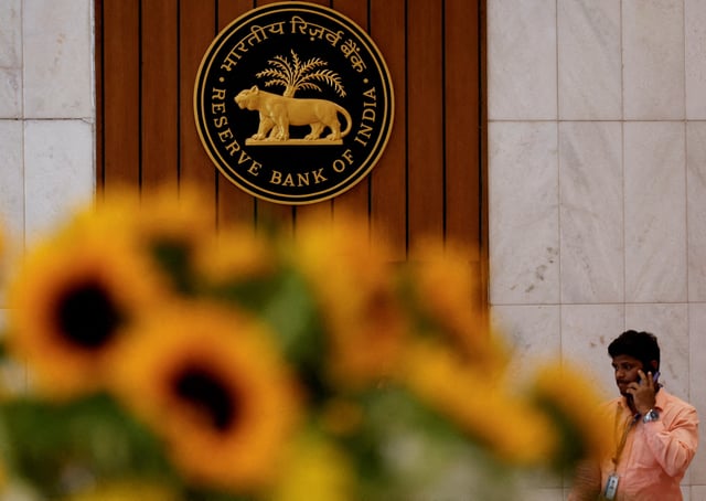 A man speaks on his phone as he walks past the Reserve Bank of India (RBI) logo inside its headquarters in Mumbai, India, February 7, 2025. REUTERS/Francis Mascarenhas/File Photo