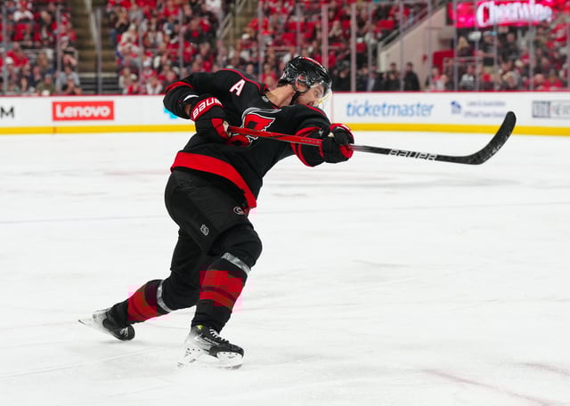 Apr 29, 2025; Raleigh, North Carolina, USA; Carolina Hurricanes center Sebastian Aho (20) scores the game winning goal in the second overtime against the New Jersey Devils in game five of the first round of the 2025 Stanley Cup Playoffs at Lenovo Center. Mandatory Credit: James Guillory-Imagn Images