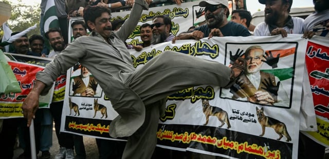 Un manifestant donne un coup de pied à une image du Premier ministre indien Narendra Modi, le 29 avril 2025 à Karachi, au Pakistan
