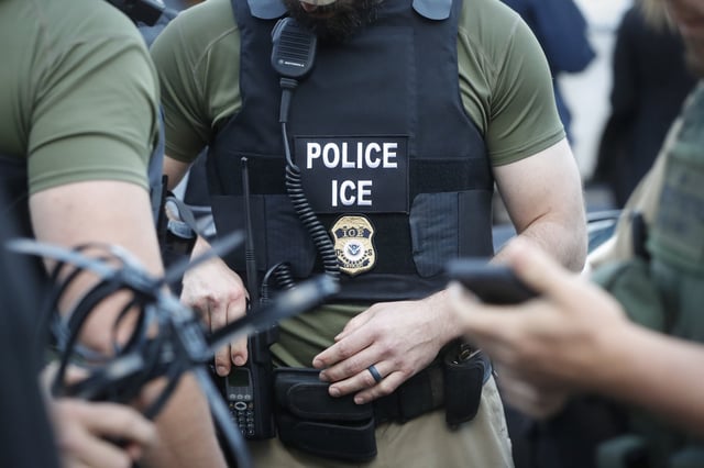Government agents muster nearby before an immigration sting at Corso&#39;s Flower and Garden Center, Tuesday, June 5, 2018, in Castalia, Ohio.
