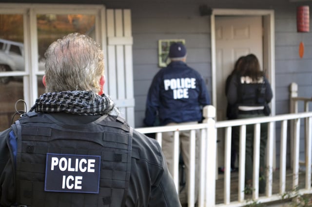 ICE agents stand outside a home in Atlanta during a targeted enforcement operation aimed at immigration fugitives, re-entrants and at-large criminals living in the country illegally.