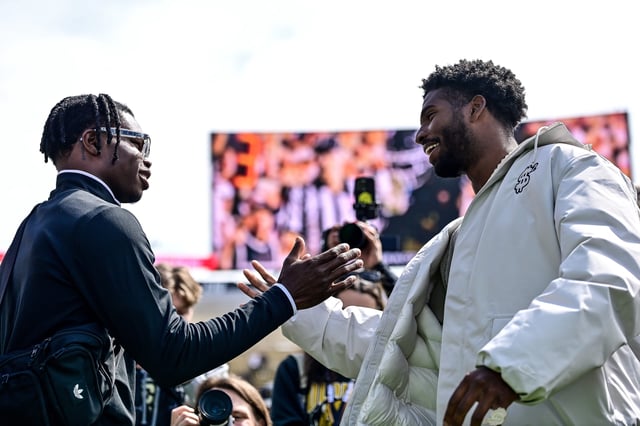 Former Colorado players Travis Hunter (left) and Shedeur Sanders meet on the field during an April 19 ceremony in Boulder to retire their numbers.