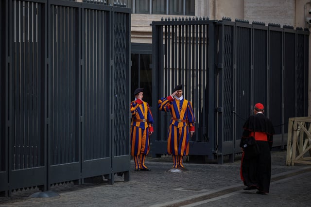 Swiss Guards salute a cardinal as he arrives for a general congregation meeting in the Vatican, as seen from Rome, Italy, April 28, 2025. REUTERS/Alkis Konstantinidis/File Photo