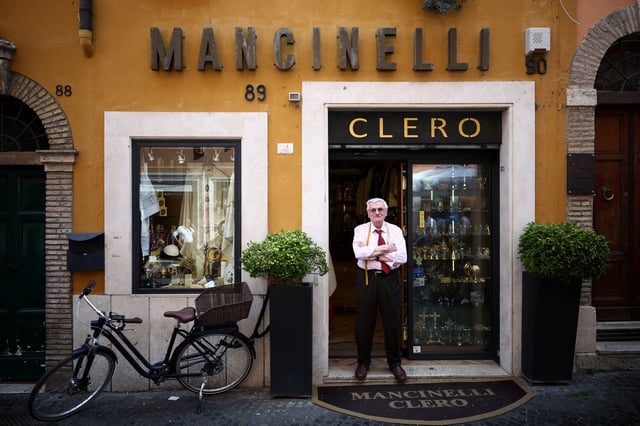 Clerical robe tailor Raniero Mancinelli poses for a portrait outside his liturgical vestments shop near the Vatican, in Rome, Italy, April 29, 2025. REUTERS/Guglielmo Mangiapane