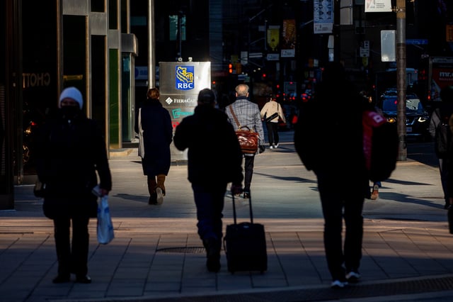 People walk near a sign for the Royal Bank of Canada in Toronto, Ontario, Canada December 13, 2021.  REUTERS/Carlos Osorio