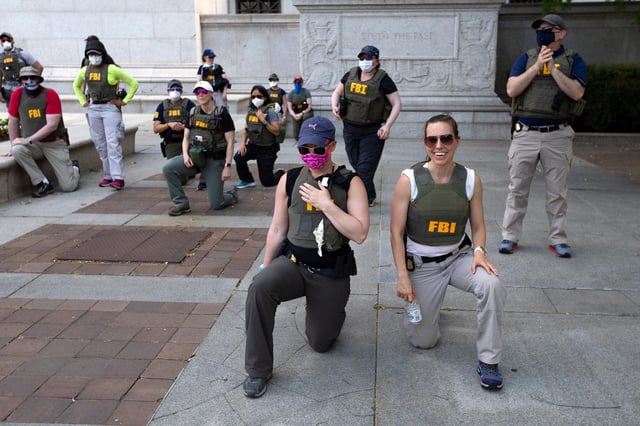 Federal Bureau of Investigation officers take a knee with demonstrators on Pennsylvania Avenue on June 4, 2020, in Washington, DC.