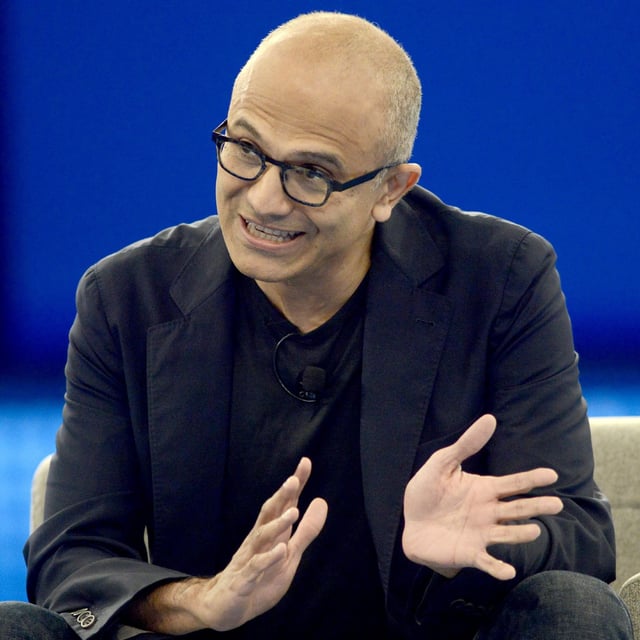 Microsoft CEO Satya Nadella speaking on stage.