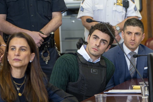 Luigi Mangione, charged in the killing of UnitedHealthcare CEO Brian Thompson, sits next to his attorney Karen Friedman Agnifilo in Manhattan Supreme Court as he attends a hearing in New York City on February 21, 2025.