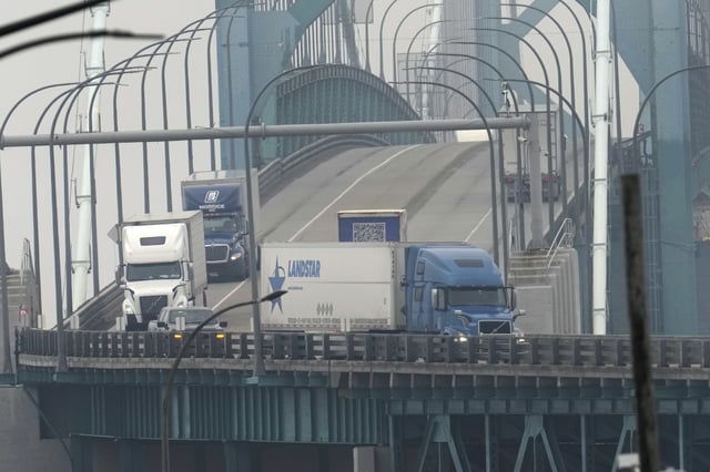 Trucks enter into the United States from Ontario, Canada across the Ambassador Bridge, Monday, Feb. 3, 2025, in Detroit. 