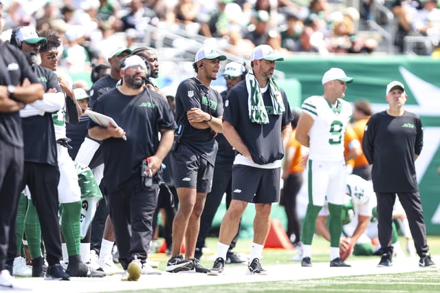 EAST RUTHERFORD, NJ - AUGUST 10: Jordan Travis #3 of the New York Jets looks on from the sideline with Aaron Rodgers #8 during an NFL football game against the Washington Commanders at MetLife Stadium on August 10, 2024 in East Rutherford, NJ.