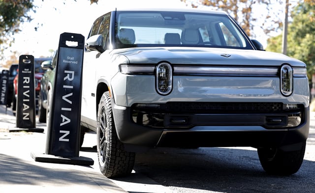 Rivian electric vehicles are parked at the Rivian Venice Hub on November 13, 2024 in Venice, California. The California-based electric vehicle manufacturer Rivian's joint venture with German automaker Volkswagen is being expanded to $5.8 billion.