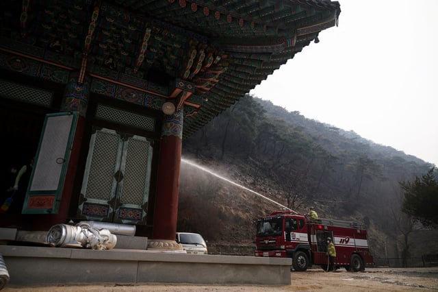 Firefighters work at the Gounsa temple devastated by a wildfire in Uiseong, South Korea, March 27, 2025.REUTERS/Kim Hong-Ji/File Photo
