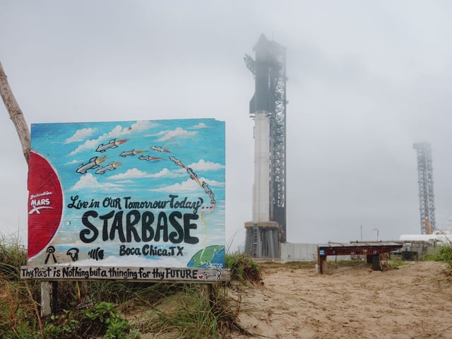 A sign supporting SpaceX stands against the backdrop of Starship at Boca Chica Beach early this year. Residents of Starbase are voting this week on a plan to make it an official city.